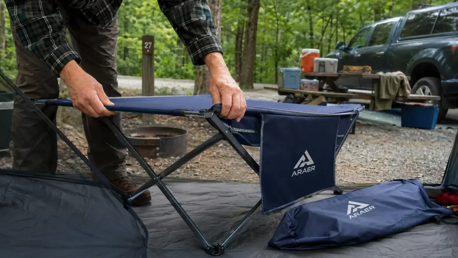 Hands unfolding the ARAER camping cot's steel frame legs at a campsite