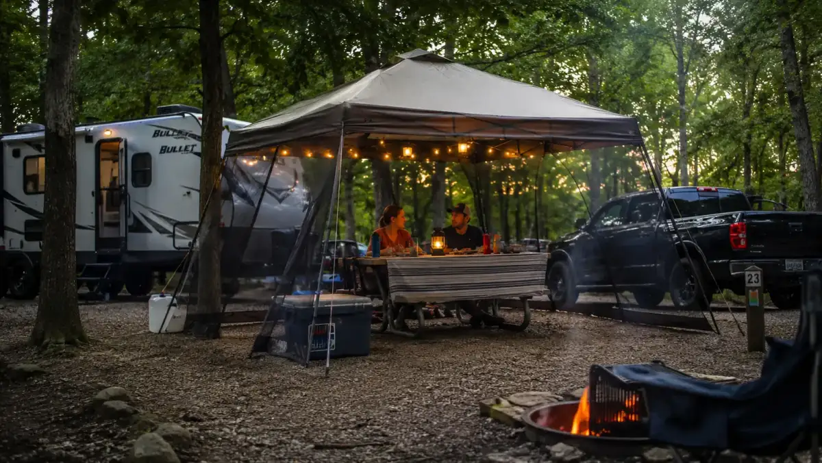 Alvantor pop up screen house canopy set up over a picnic table at a wooded campsite